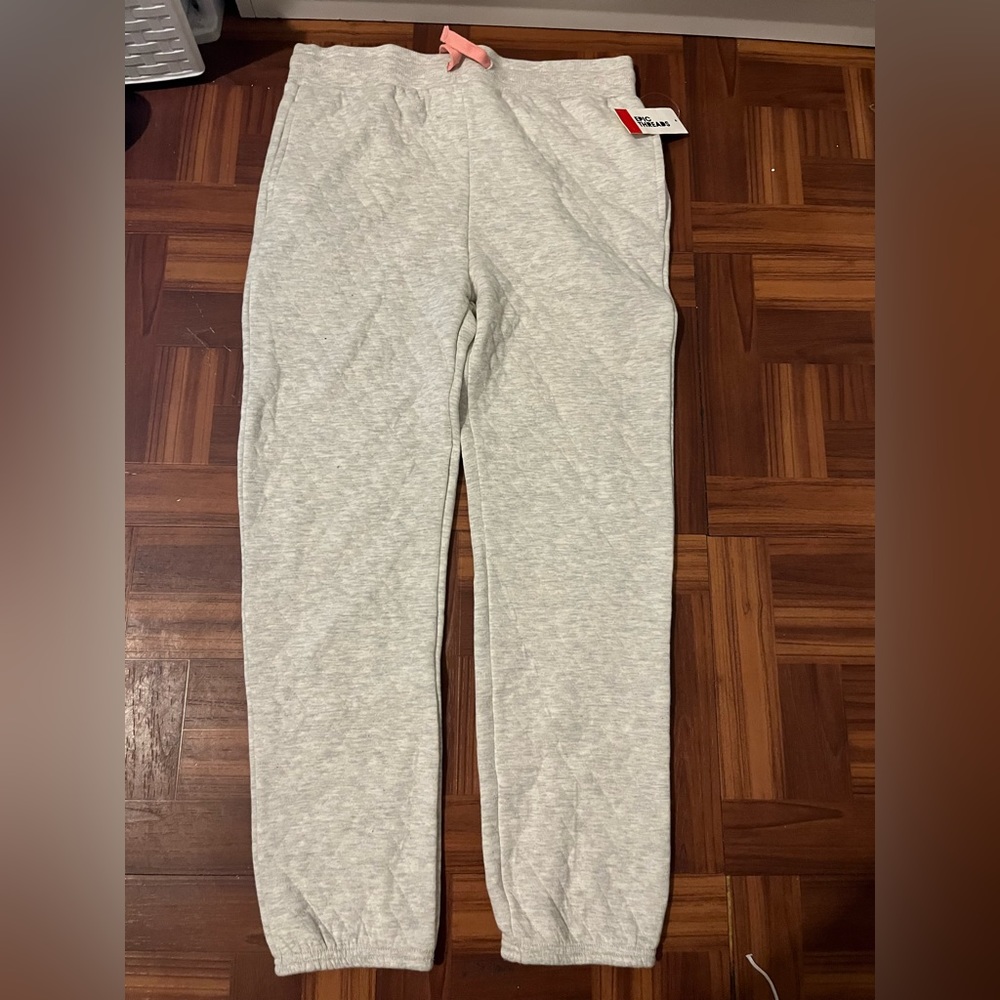 beige sweatpants with pink string